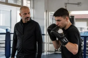 Christophe Tiozzo transmet son expérience à un jeune pratiquant dans une salle de boxe associative française.