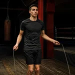 Un jeune boxeur s'entraîne avec une corde à sauter boxe dans un gymnase réaliste en France.