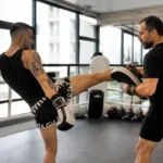 Un pratiquant en plein entraînement de muay-thaï intensif avec dida diafat