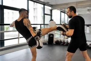 Un pratiquant en plein entraînement de muay-thaï intensif avec dida diafat