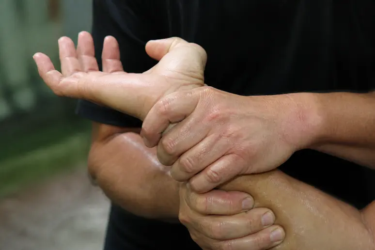 Mains exécutant une clé de poignet pour se dégager d'une saisie en self-défense.