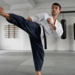 Pratiquant de Krav Maga tente un high kick, montrant la souplesse de hanche nécessaire.