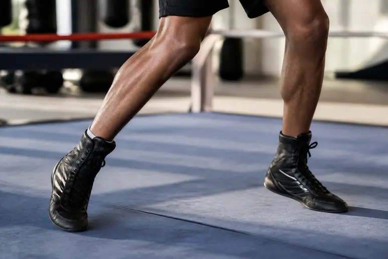 Pieds d'un boxeur en appui stable avec un alignement biomécanique correct lors de l'entraînement.