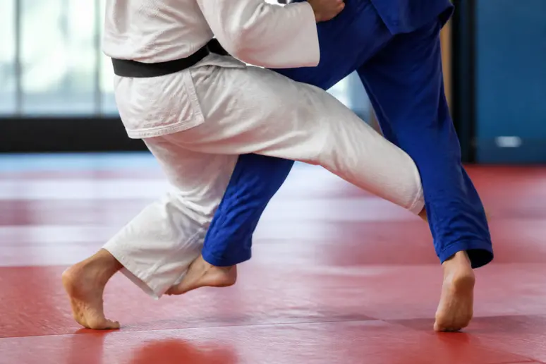 Pratiquant d'arts martiaux réalisant un Ashi Uchi Mata avec un balayage de jambe vif.