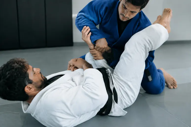 Pratiquant de juji gatame décollant le bassin au sol pour redresser la position