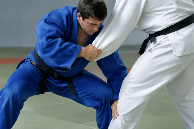 Judoka baissant son corps pour placer un bras entre les jambes lors d un kata guruma