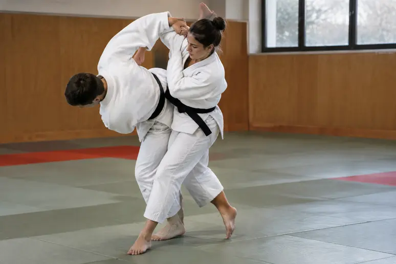 Pratiquant de judo effectuant le pivot complet de la hanche pour le koshi guruma.