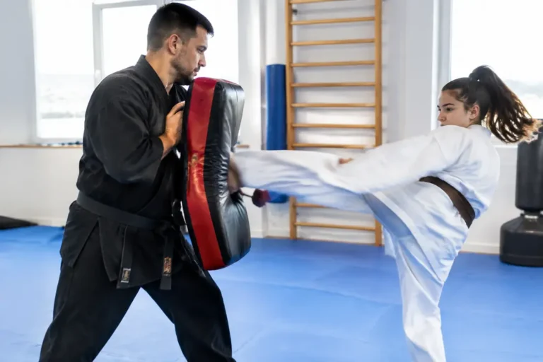 Pratique du Krav Maga avec un bouclier de frappe en mousse dense dans une salle d'entraînement