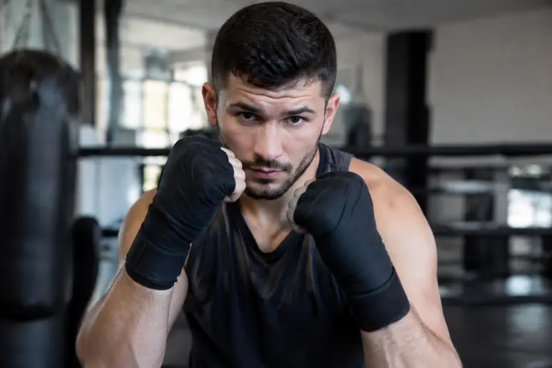 Boxeur en position de garde de base avec les mains bien placées pour protéger son visage.