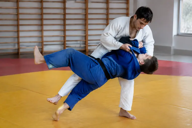Judokas exécutant la variante latérale du yoko-tomoe-nage sur un tatami