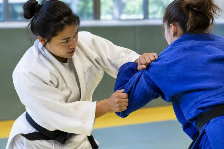 Saisie des deux manches par un judoka pour exécuter la variante sode tsurikomi goshi