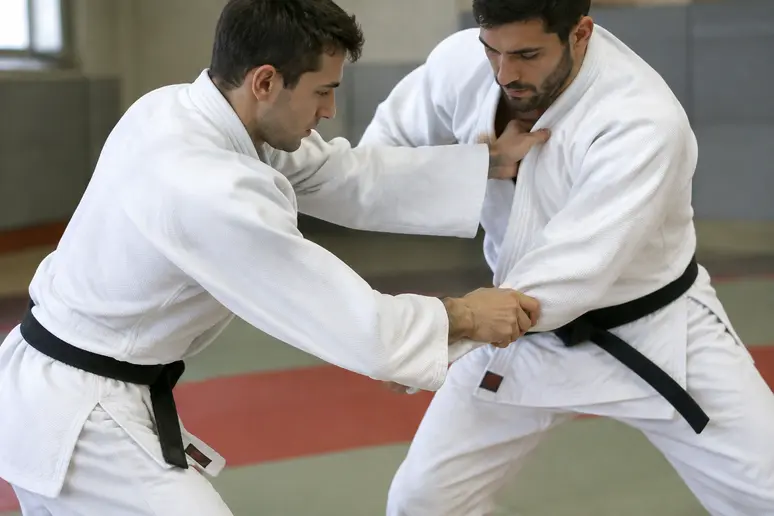 Pratique de l'uki otoshi avec une saisie décroisée sur le revers et la manche du judogi.