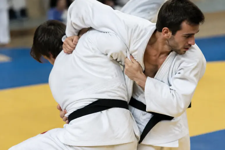 Pratique d'un ura nage en gros plan avec contact serré des hanches sur le tatami.