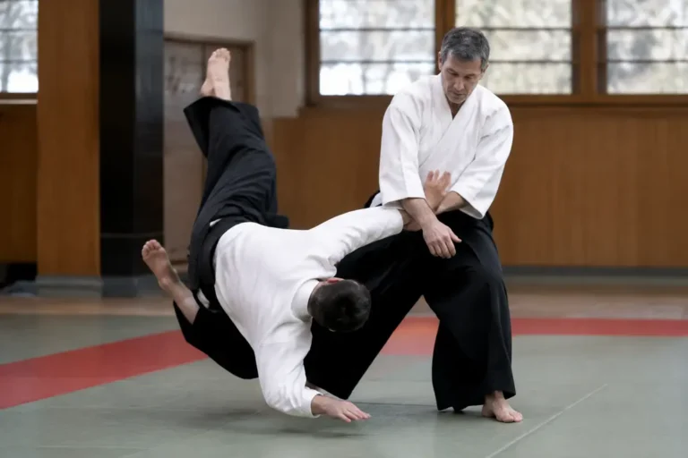 Pratique de l'ura nage sur tatami dans un dojo d'arts martiaux lumineux.